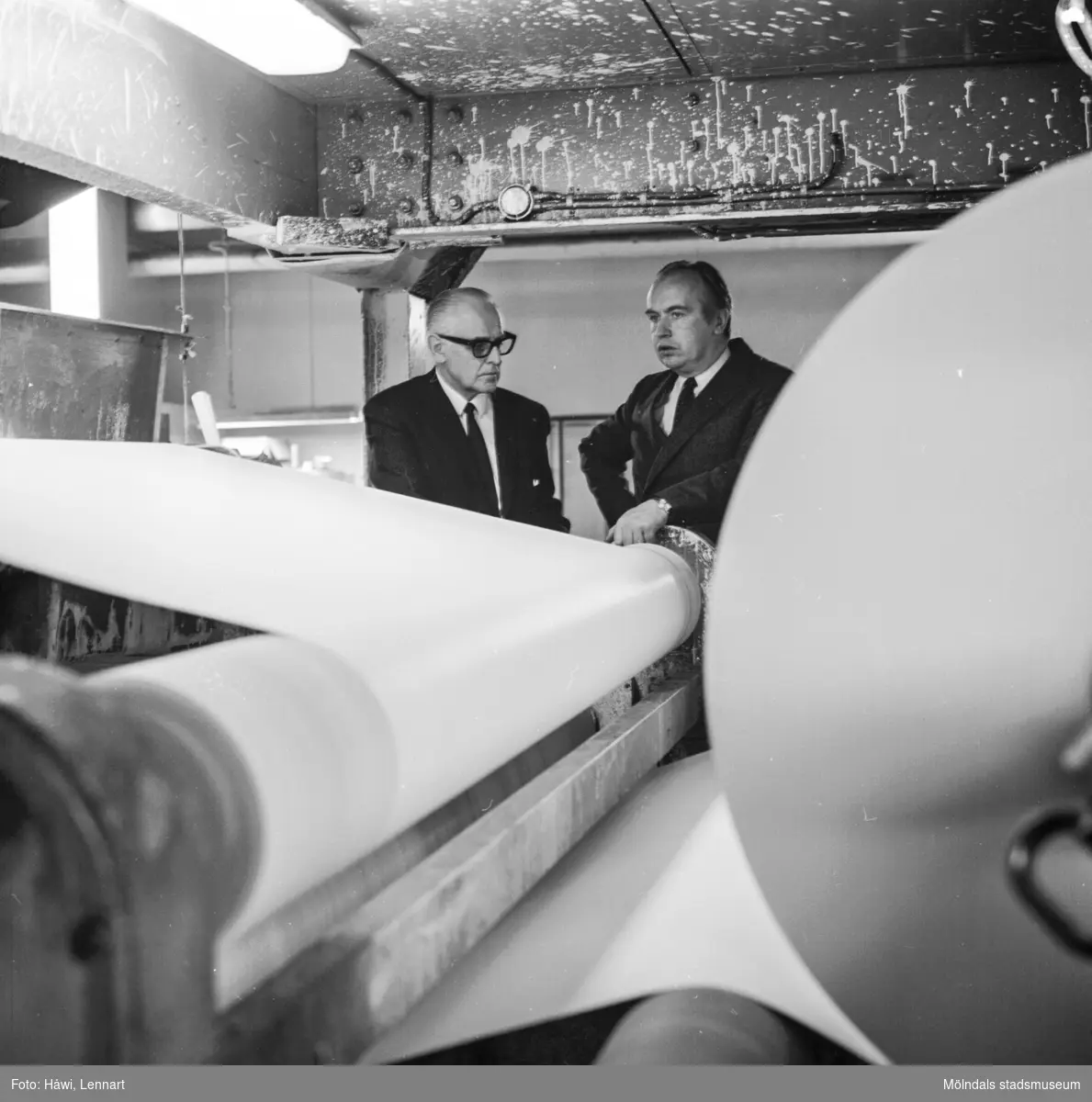 Pappersbruket Papyrus direktör William Tibell och en annan man står vid maskin på Papyrus i Mölndal, 14/12 1970.