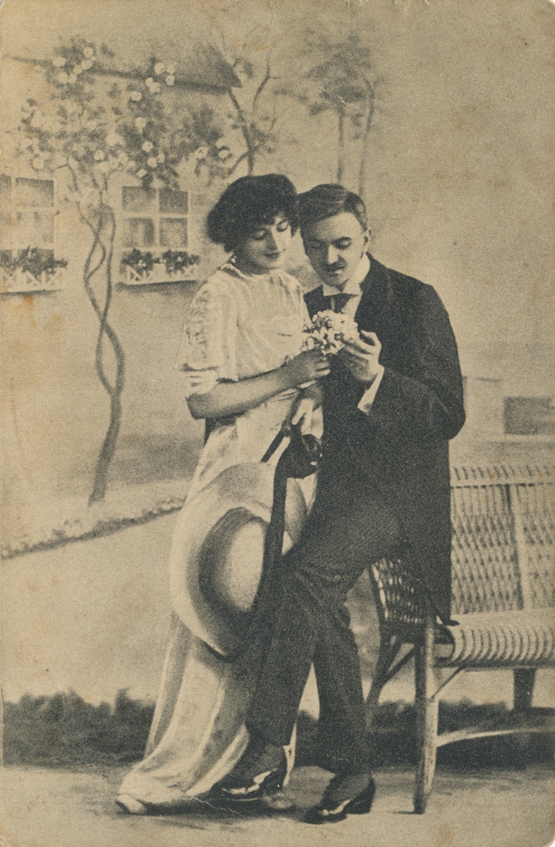 Postkortmotiv av ei kvinne og en mann med en blomsterbukett i fotoatelier.