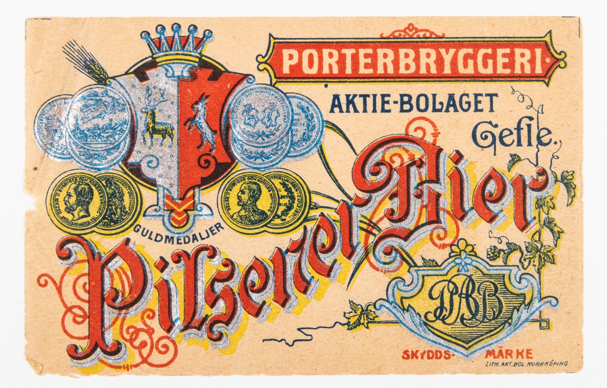Öletikett: Pilsner-Bier. 
Motiv av malt, humle och Gästrike-Hälsinge vapen.
Del av samling bryggerietiketter av papper, från olika bryggerier i Gävle.
