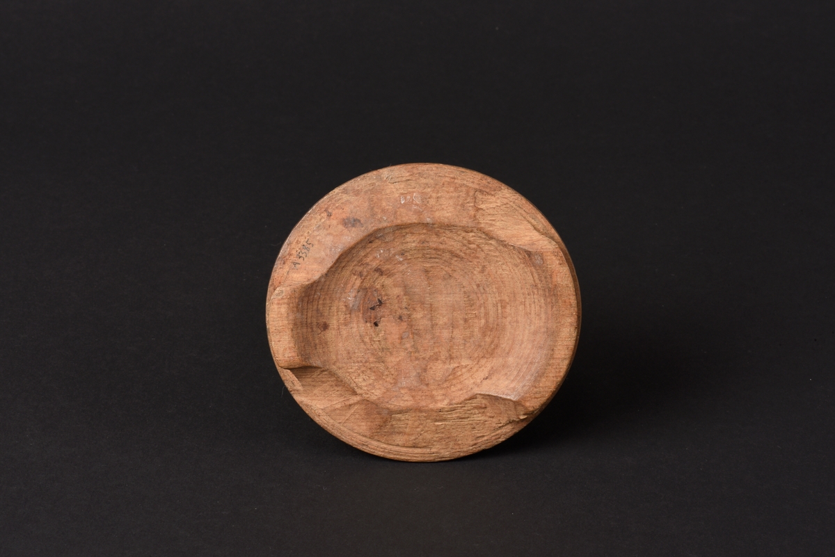 Rund svarvad smörask med lock, tillverkad av trä. Locket har ett rektangulärt utskuret handtag.