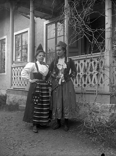 Två kvinnor i folkdräkt, vid prästgården, Lillhärad.