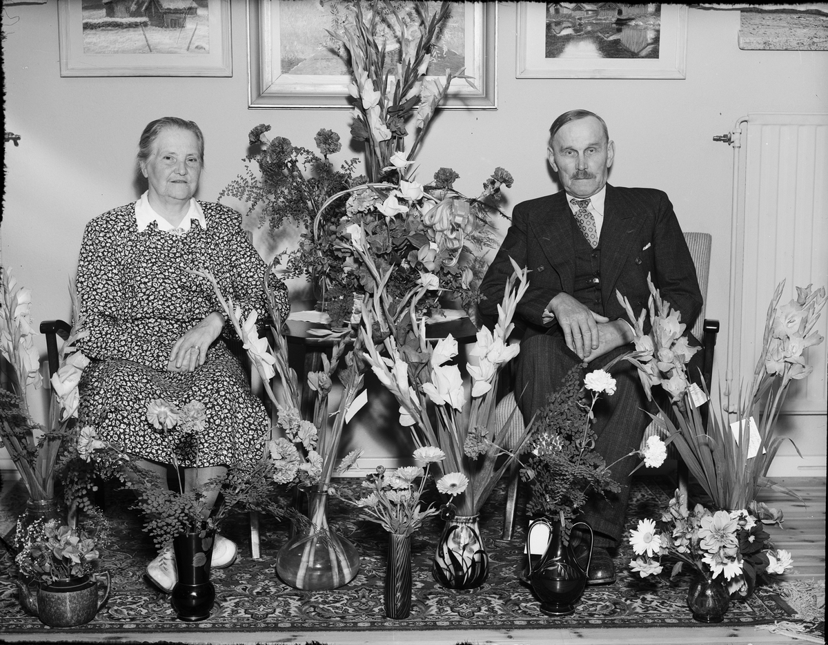 Man och kvinna omgivna av blommor, Östhammar, Uppland