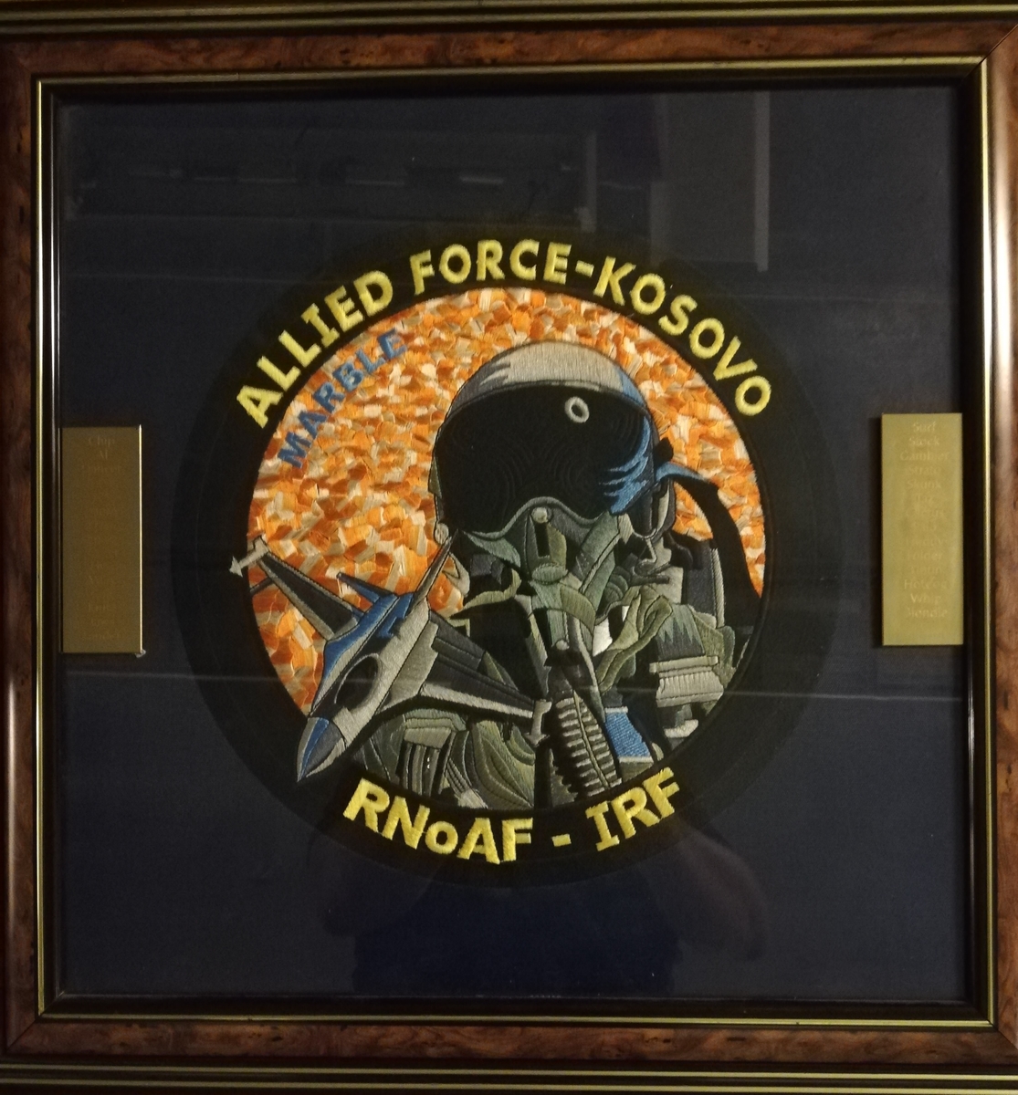 Bildet viser stor patch for Allied Force Kosovo. Messingplater med inngravert callsign for deltakende personell.