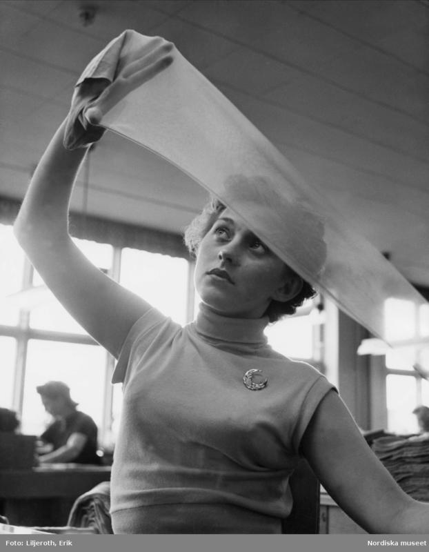 Bildet viser en kvinne som strekker ut en nylonstrømpe med hendene sine.