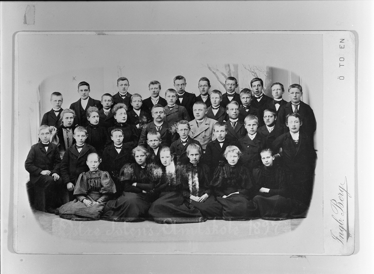 Gruppebilde av elever og lærere ved Østre Toten Amtskole 1897. Styrer Berhard Heggen nummer fire fra venstre i tredje rekke, og til venstre for han trolig frøken Gauslaa. Ellers er ingen identifisert.
