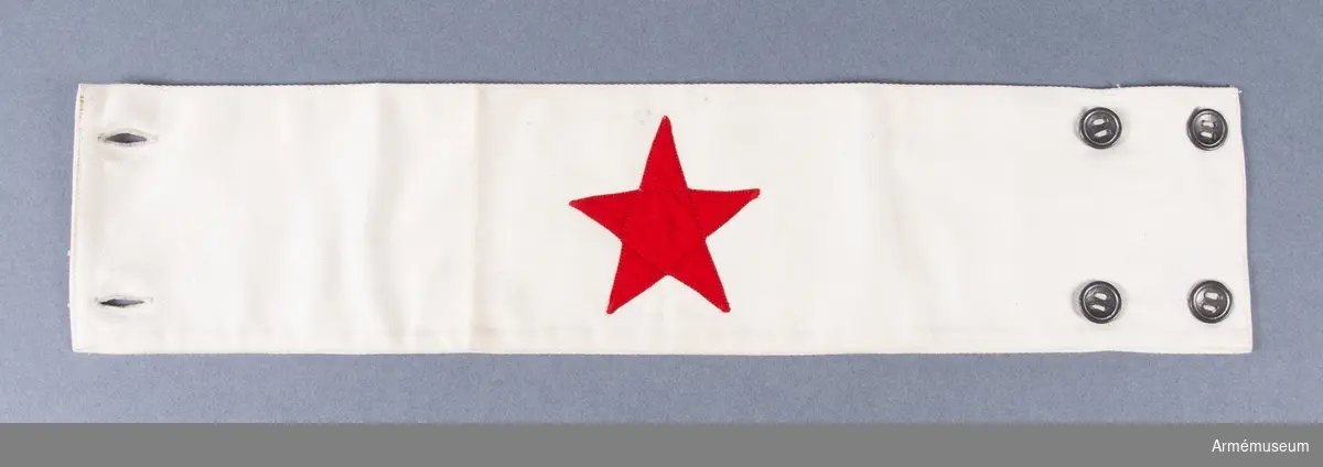 Armbindel tillverkad av vitt tyg med en applicerad röd stjärna.