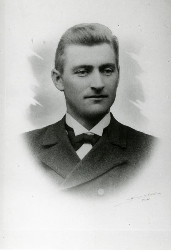 Portrett av en ganske ung mann med skjorte, sløyfe og jakke.