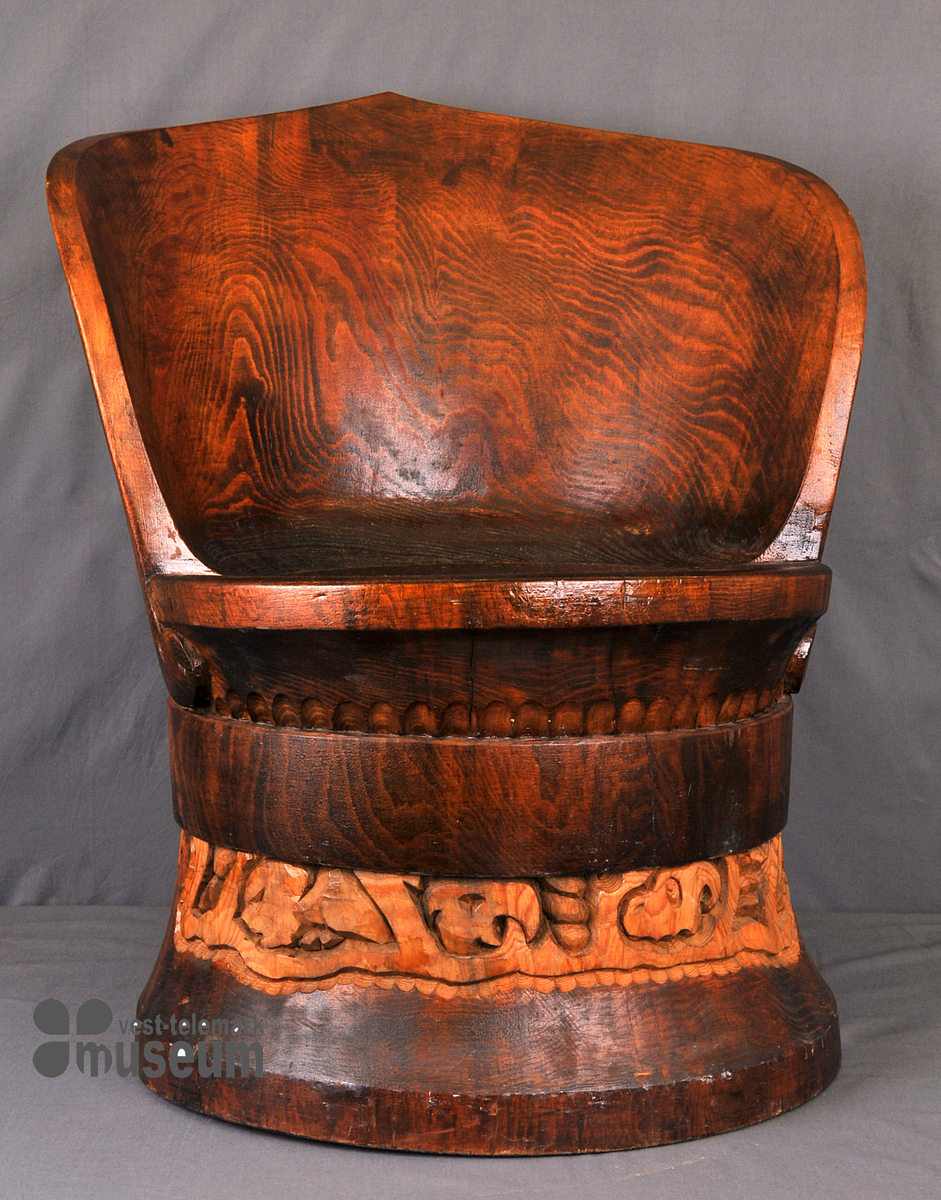 Stolen er brunbeisa med utskorne motiv bak på ryggen og på nederste halvdel.