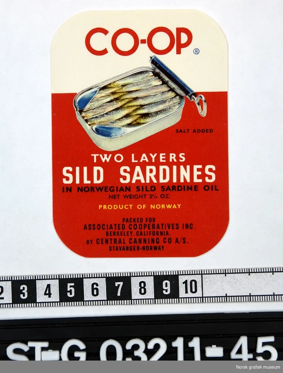 Etikett i rødt og hvitt med en åpnet sardinboks som hovedmotiv. 

"Two layers sild sardine in Norwegian sild sardine oil"