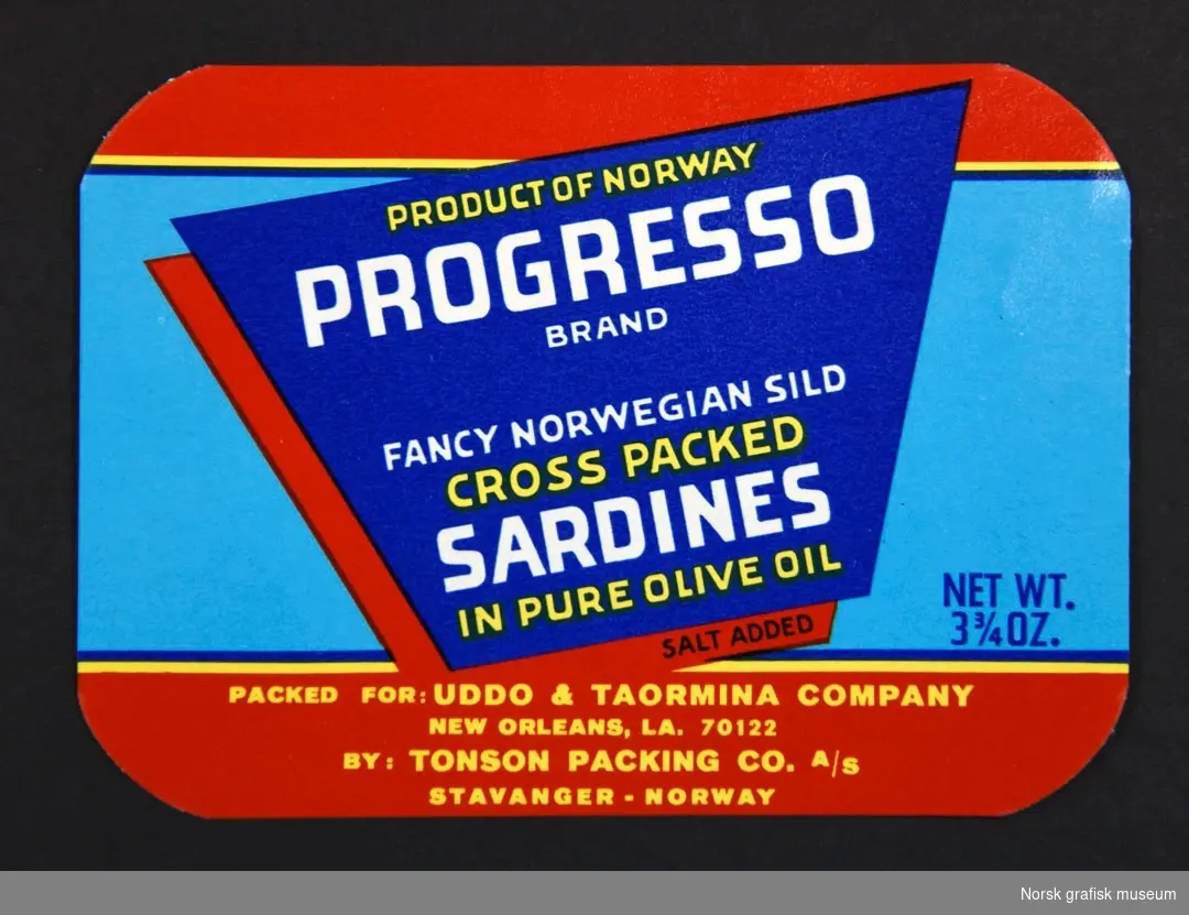 Etikett i rødt, blått og turkist, med tekst i hvitt og gult. 

"Fancy Norwegian sild sardines in pure olive oil"