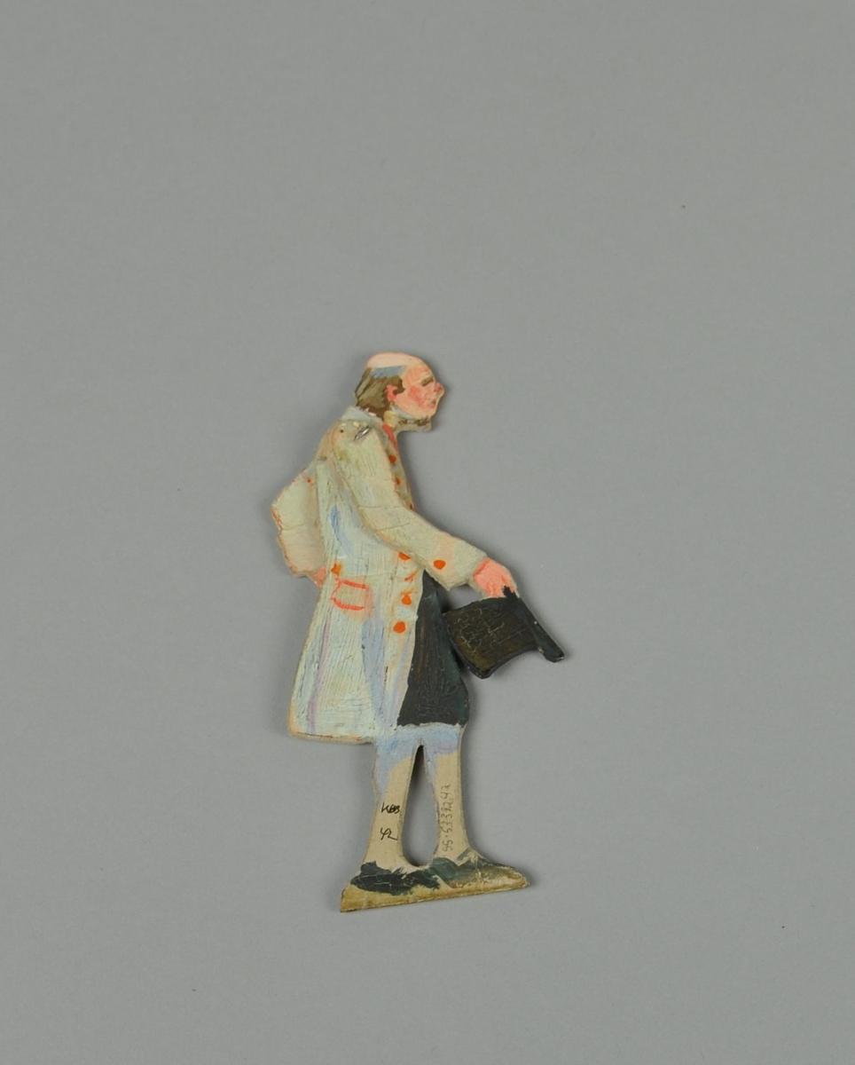 Figur av papp. Figuren forestiller stående mann i sideprofil, med bevegelige armer. Figuren er malt på begge sider.
