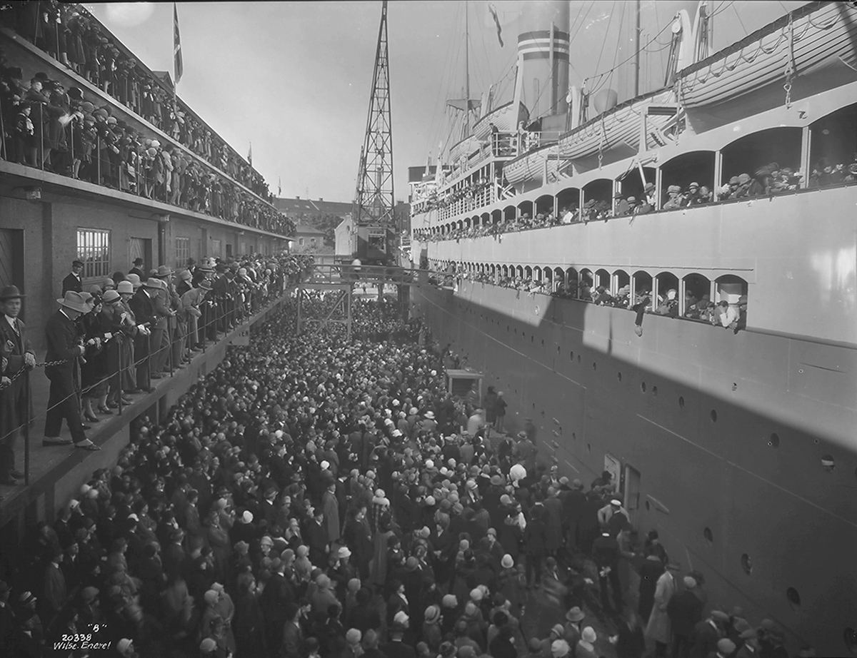 DS Stavangerfjord klar til avgang. Mange mennesker ombord vinker til de på kaia, Den Norske Amerikalinje A/S. Fotografert 1924.