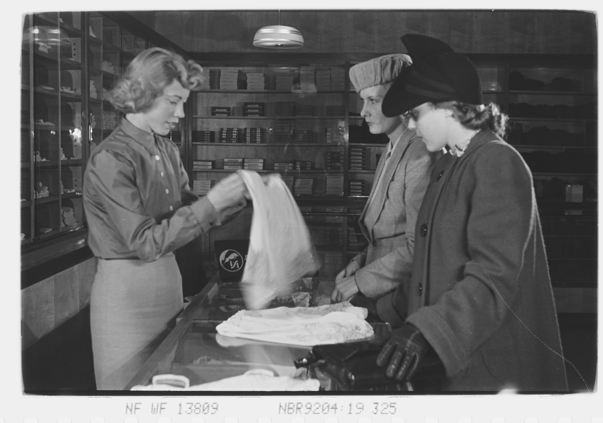 Butikkhandel. Ekspidetrise og to damer ved disken. Fotografert 1940.