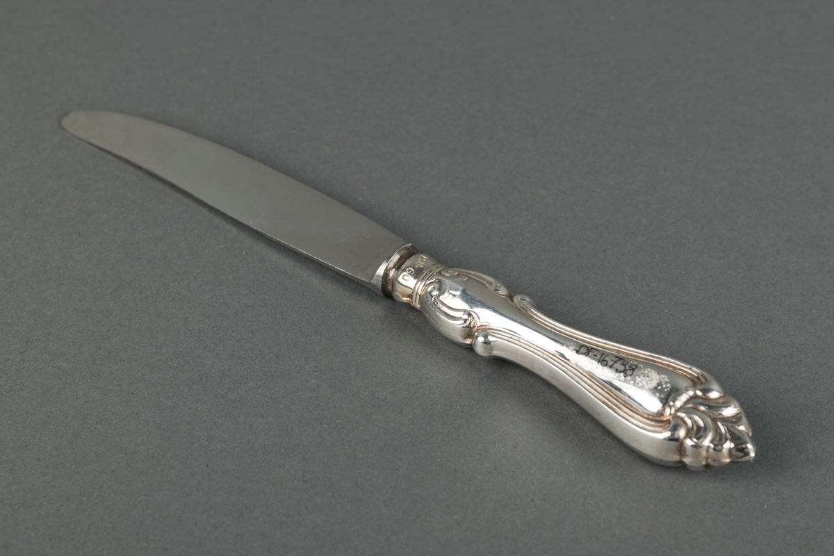 Kniv med dekorert skaft. Knivblad av stål og skaft av sølvplett.
