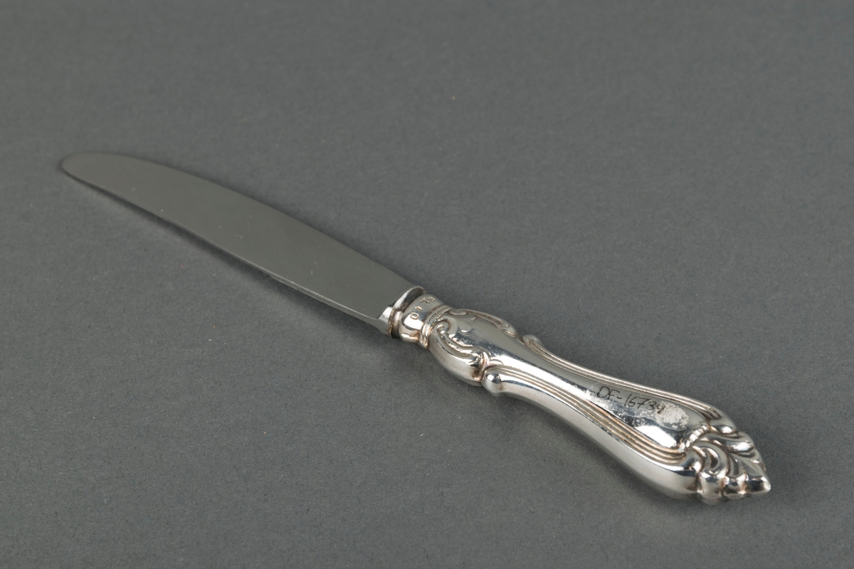 Kniv med dekorert skaft. Knivblad av stål og skaft av sølvplett.
