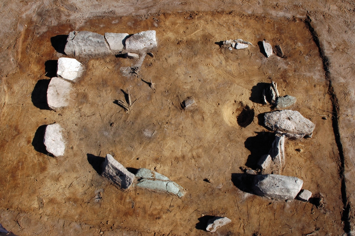 En ofylld, rektangulär stensättning, A 2512 fotograferad i samband med en arkeologisk undersökning av gravfältet RAÄ Barnarp 29:1, L1974:2724 på Torsvik i Jönköping. I högra bildkanten syns en sydport med takhäll, se även JMF.00328:10.