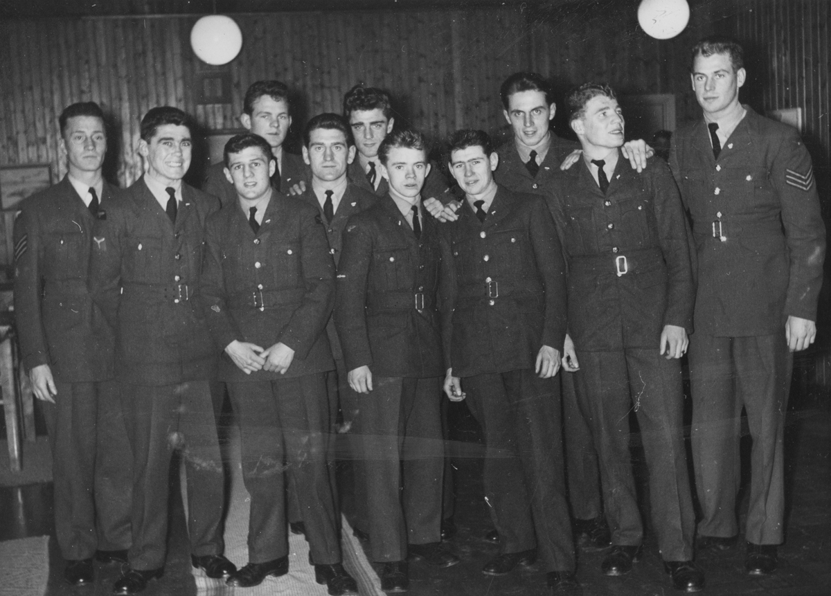 Grupporträtt av boxningslaget från Royal Air Force vid boxningsgala i Halmstad, 1950-tal. Elva män uppställda inomhus.