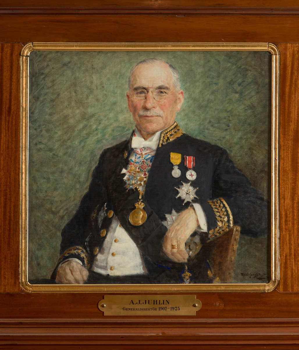 Porträtt i olja av generaldirektör Julius Juhlin.

Duken är fäst på en träplatta. En mässingsskylt med text: "A.J. Juhlin, Generaldirektör 1907-1925" tillhör.