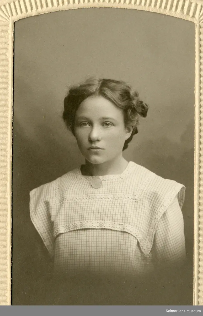Porträtt av Esther Sivgård, klädd i vit blus eller klänning.