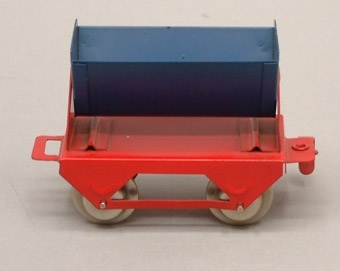 Tippvagn med blåsvart behållare och rött underrede.