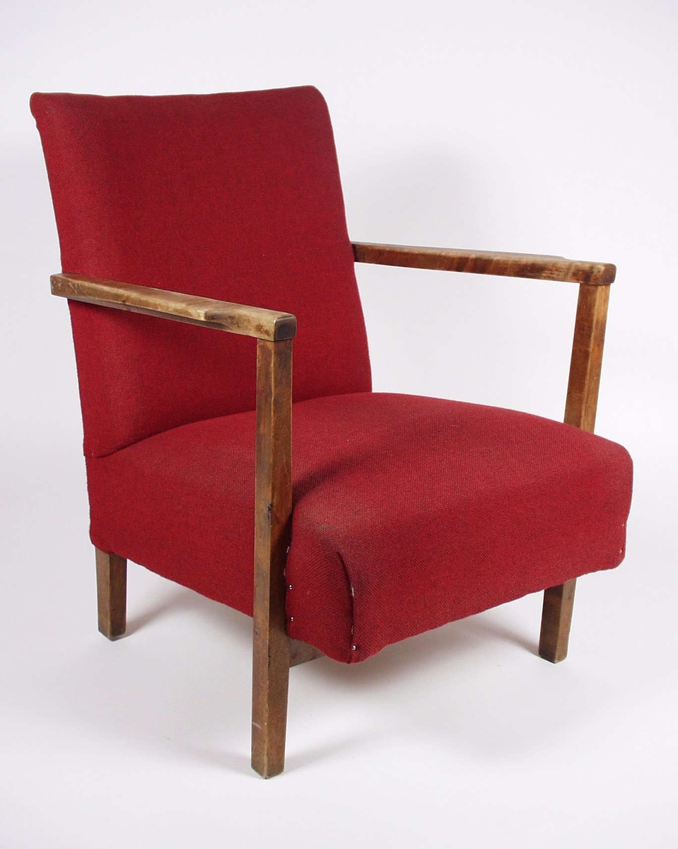 Stolen er i bjørk og gran, med stoppet sete og rygg i rødt ullstoff.