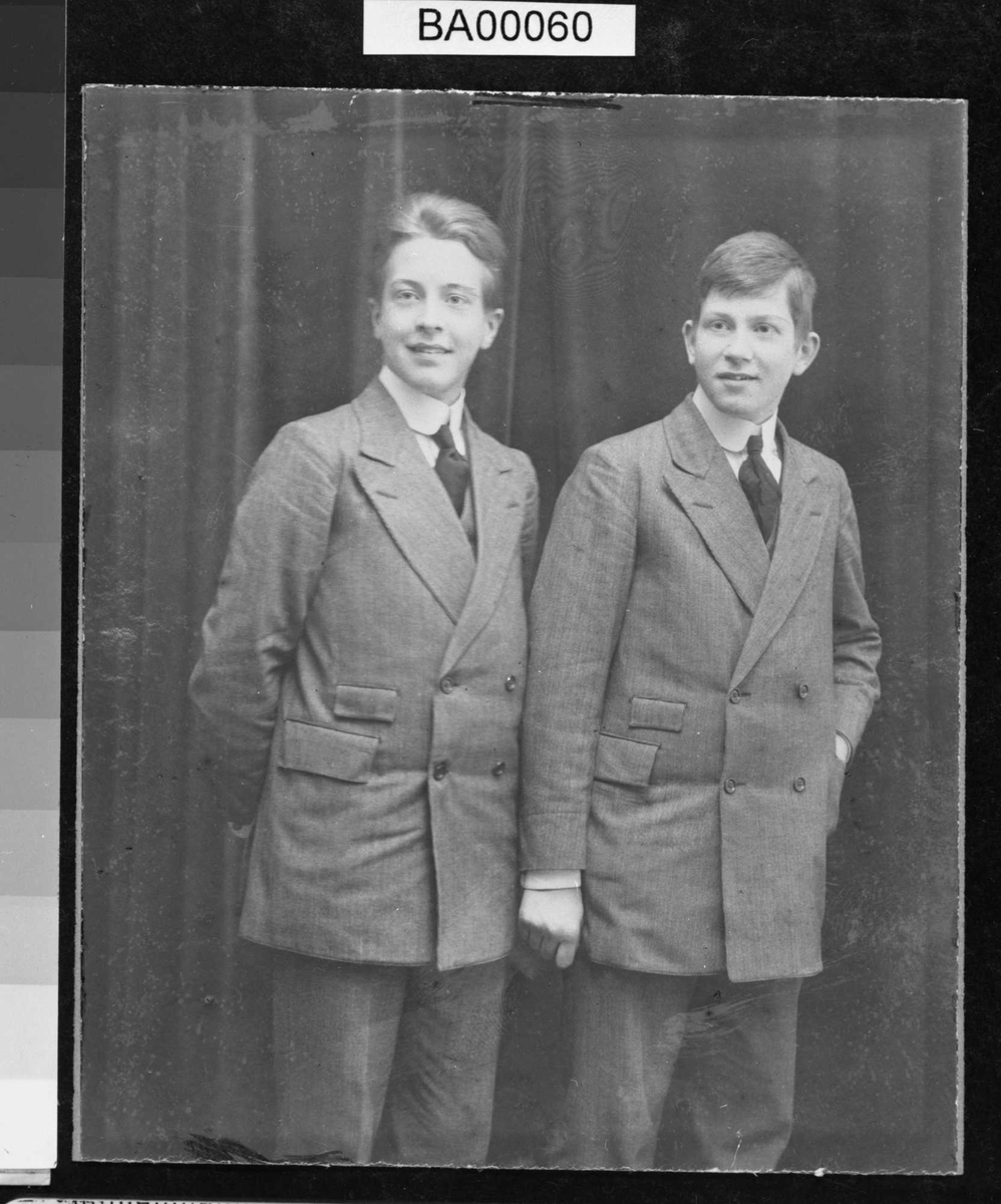 Fotografi av to unge menn i stripet dress.
