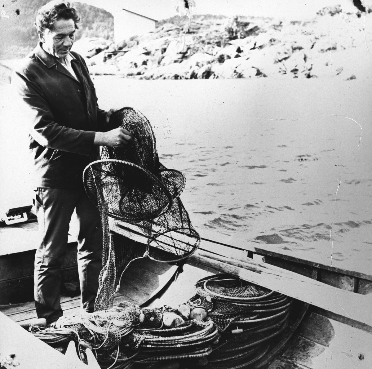 Mann ombord i båt, ordner med åleruser.