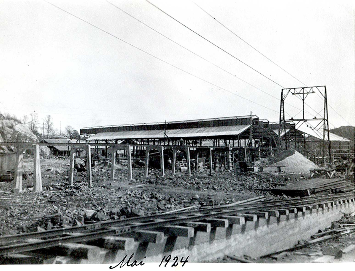 "xx/05-1924" Nitriden. Bygninger for steking av elektrodekull. Bærende konstruksjoner for skinnegang, "høybanen", i forgrunnen. Taubanewire. Kai anlegget til høyre.