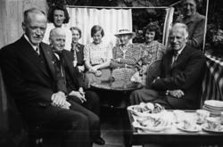 På verandaen hos baker Brun, gruppebilde, mann, kvinne