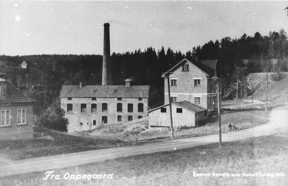 Fabrikkområde (trevare) med høy pipe og bygninger i tegelstein.