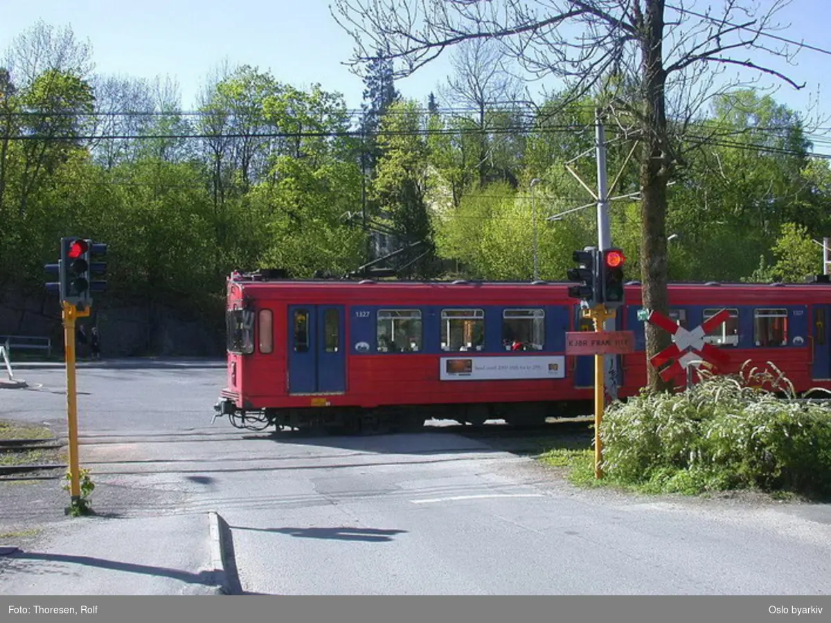 Oslo Sporveier. Kolsåsbanen. T-banevogn 1327, serie T6, på linje 4 over planovergangen ved Gjettum stasjon.