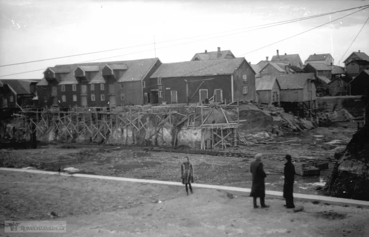 Halstensen brygga i bakgrunnen..Fra Inste Kuholmen mot bryggene til handelstedet. Forskalinga i forkant av bryggene er til kaia som havnevesnet byggde i forkant av brygga..(Filmbeholder datostemplet Sept 1941) Havnearbeid i søre Bjørnsund. .Havnearbeidet startet opp 1937 og ble avsluttet under krigen.