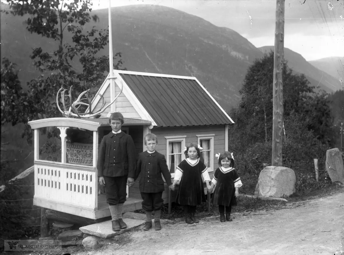 Johan Alnæs sine barn utenfor lekestua..Dukkestue, Verma (Alnæs-Familien) .Dukkestua kom til Romsdalsmuseet 1980. Huset er laga av Knut Foss. .