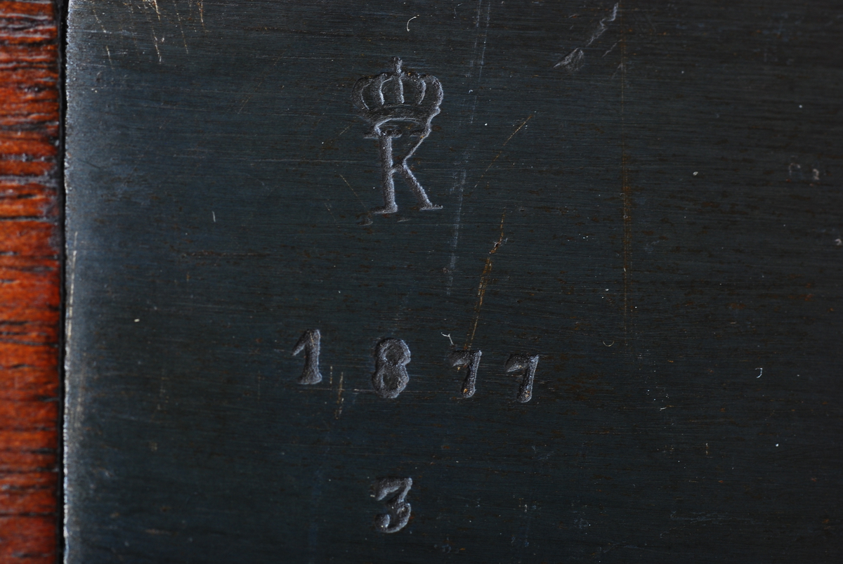 Pipen og forskjeftet er merket med Kongsberg-K. Låsekassen er merket 1877.