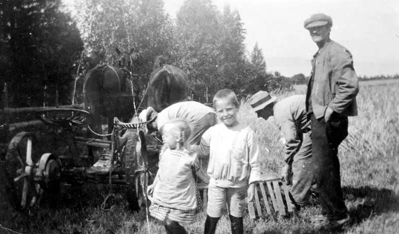 Skuronn på Skavang, Helgøya. Hest med slåmaskin. Hans Moen ved slåmaskina. Hans Martinsen Moen f.1894 ved avleggerbrettet. Barna er Ole Magnus Moen f.1916 og Anne Moen f.1918.