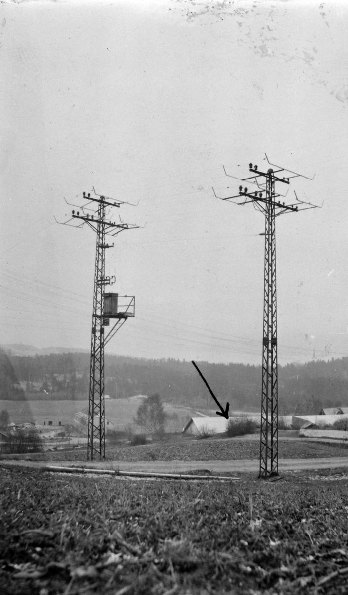 To høyspentmaster ved Ringsaker stasjon 1920-25. I midten er taket på et potetlager fra første verdenskrig. Ringsaker og Nes Kraftanlegg.
