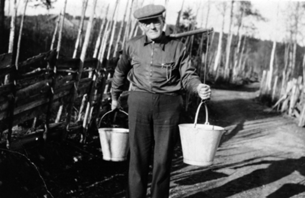 Ingmar Østeraas bærer vann i sinkbøtter med vassåk, Kastbakken, Moelv. 1943.