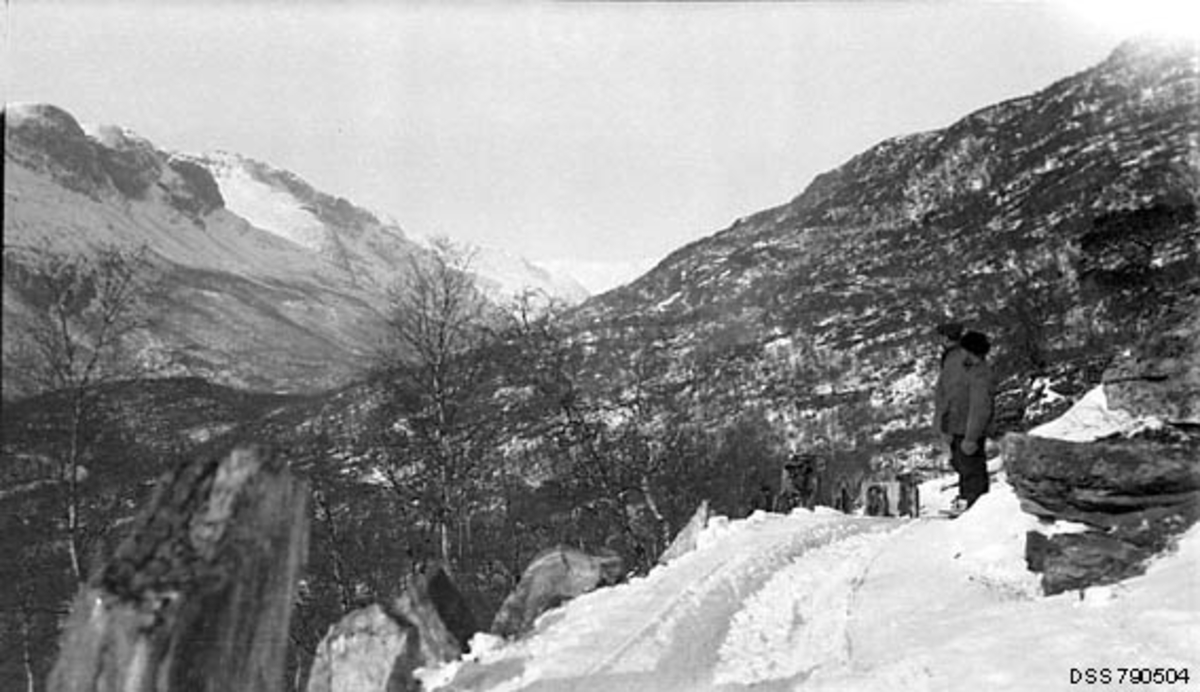 to menn, veg med kantstein, utsikt over dalen, vinter
