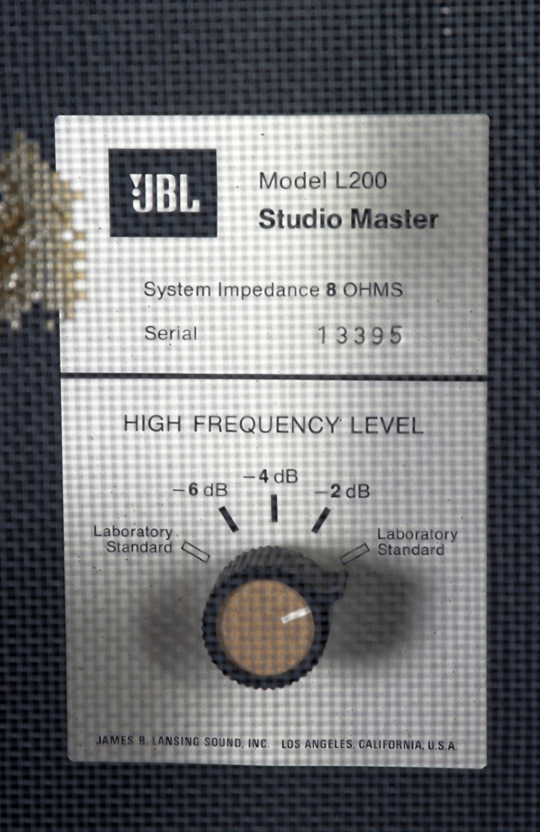 Toveis høyttaler (to drivere og to høyttalerelement: 15" + 1" hornelement for høyfrekvent lyd). Impedans 8 ohm, 100 watts kapasitet. Gulvmodell i kabinett av valnøtt. Grillen, opprinnelig i skumgummimønster, er løsnet/avvrevet.