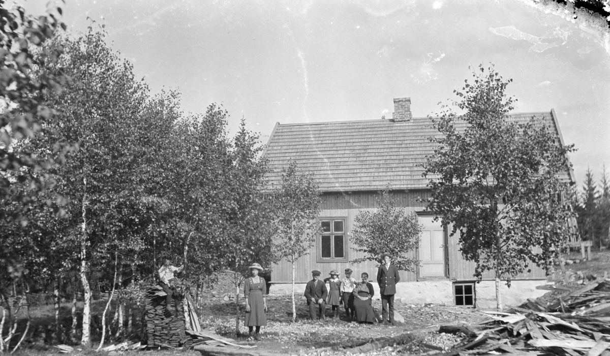 Eksteriør, Nordsveen, Stavsjø, Hedmark. Familien samlet foran huset. Fra venstre er Osvald f.1909, Martha f.1900, far Kristian Olsen (1868-1951), Laura (1905-1986), Jørgen f.1902, mor Lina (1870-1953), Albert f.1898.