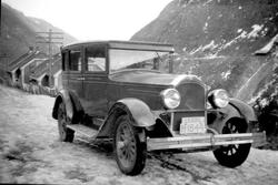 Bil på veien ved Våer. Boliger samt Vemork-sporet i bakgrunn