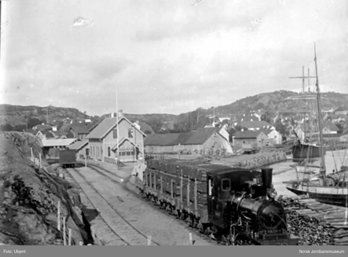 Damplokomotiv med godstog lastet med torvbunter på Lillesand stasjon