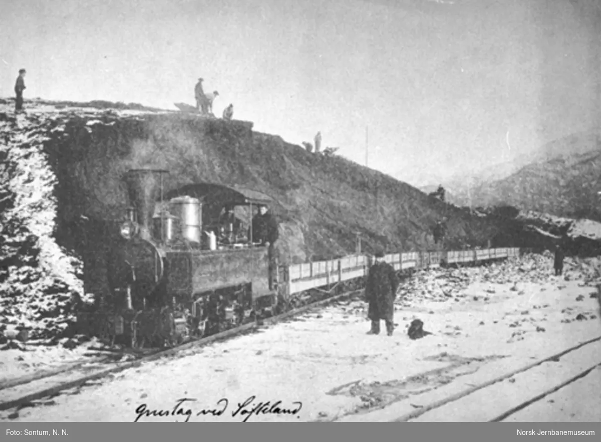 Damplokomotiv med grusvogner i grustaket ved Søfteland