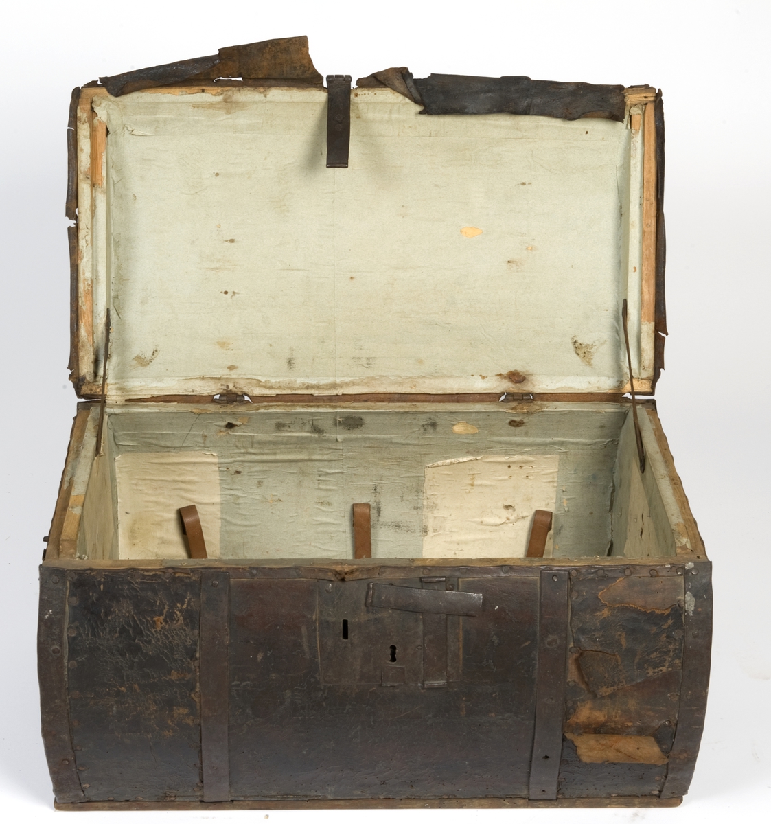 Sylinderformet reisekiste, trukket med lær. Innsiden er avdekket med papir. Jernbånd rundt kisten.