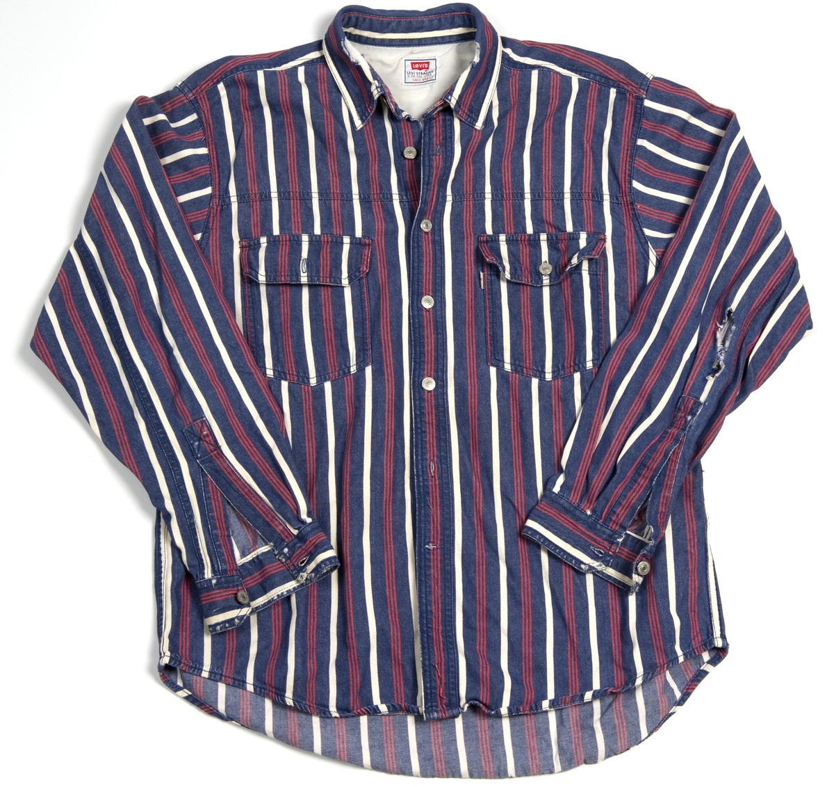 Levis-skjorte med blå, røde og hvite striper, str. L.
Det er hull i høyre erme og i kragen.