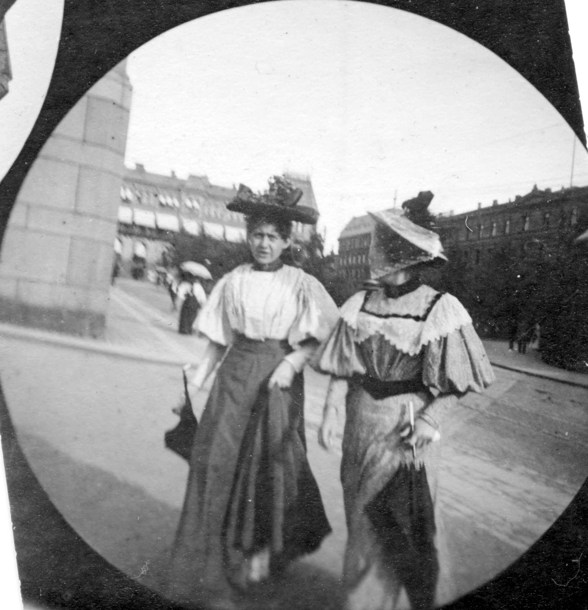 To kvinner spaserer ned Stortingsgata i Oslo. Wessels plass i bakgrunnen med Løvebakken til venstre.