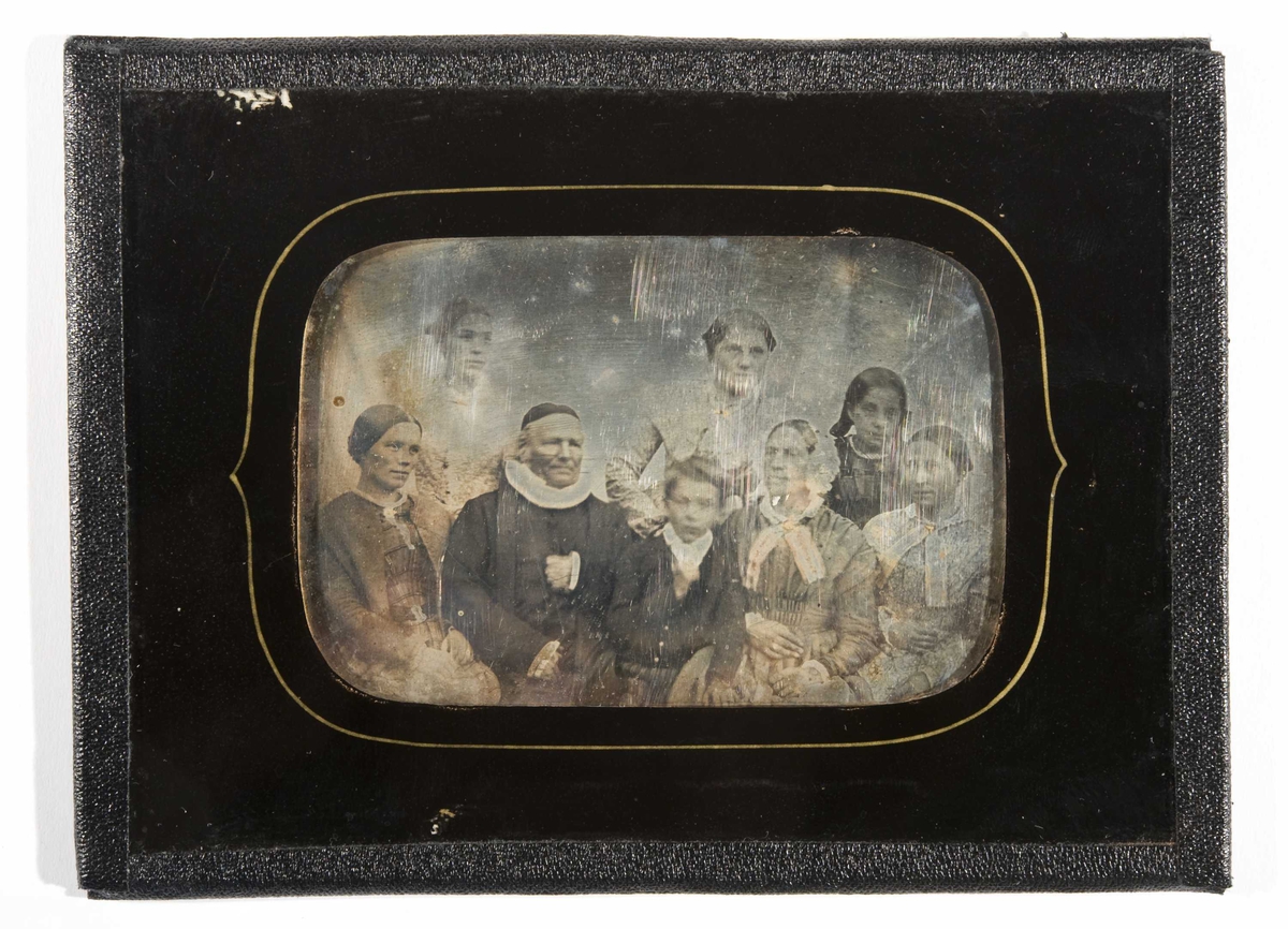 Daguerreotypi. Portrett av familie, sokneprest Johan Christian Tandberg (1786-1860), gift i 1819 med Ulrikke, født Faye (1799-1856) med fire døtre og yngste sønn, "I Modum fra 1786-1860", ca. 1850. Halvfigur med kolorerte partier på drakt, samt smykker og tekstil pålagt gull.