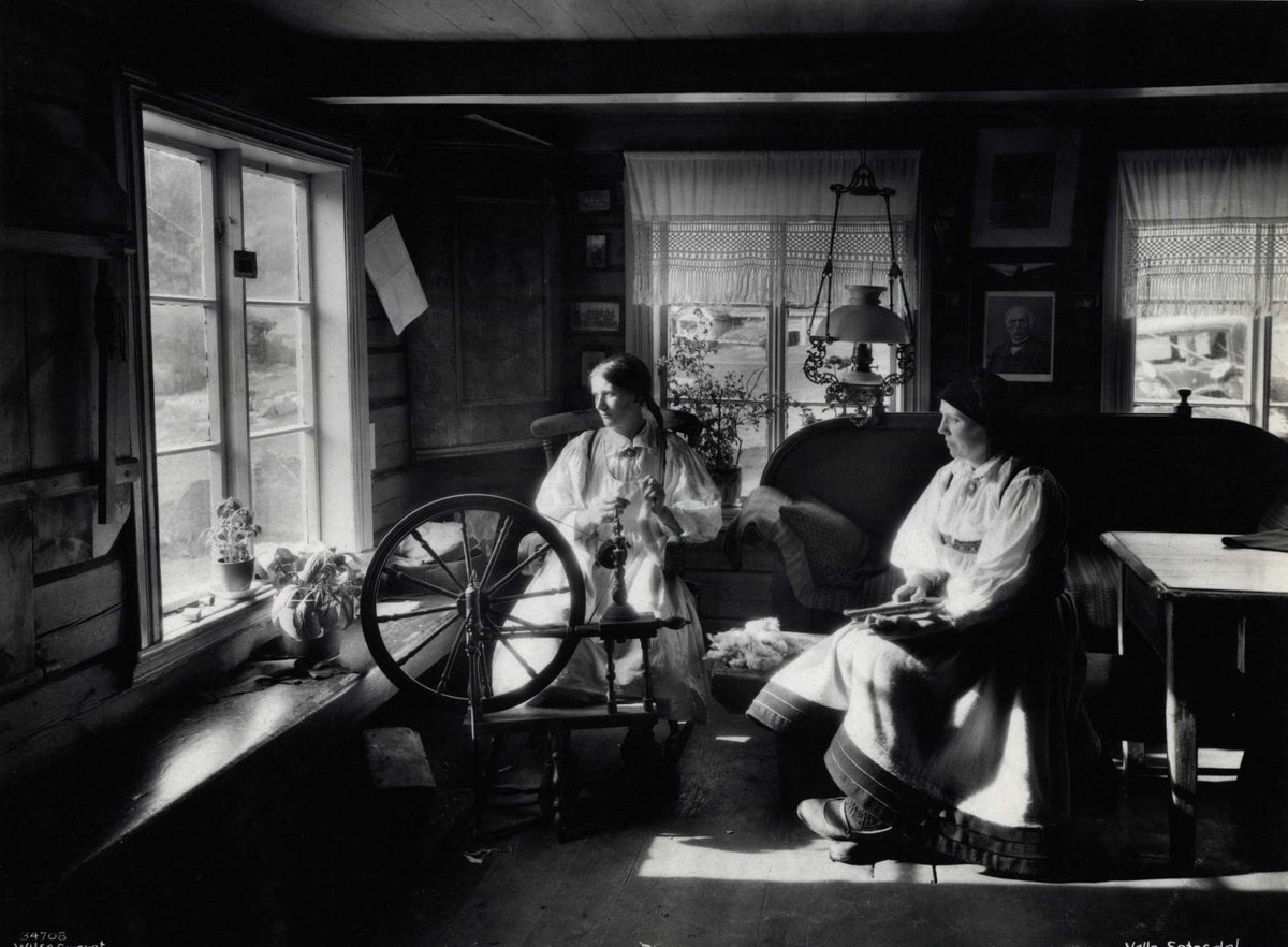 To kvinner spinner og karder i en stue. Valle, Setesdal, Aust-Agder, antagelig 1929.