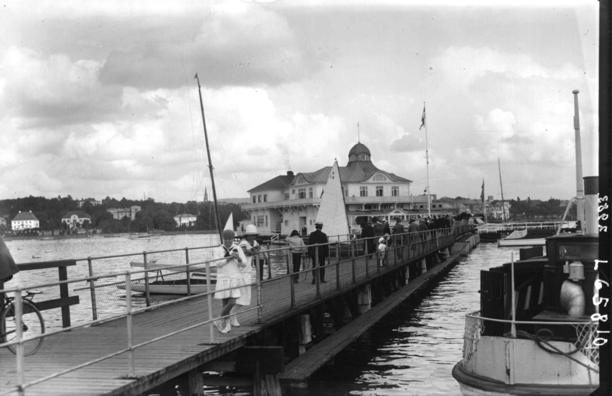 Oslo, Frognerkilen. Restaurant "Dronningen". Mennesker på gangbro og båter på vannet. Piker i matrosdrakt i forgrunnen.