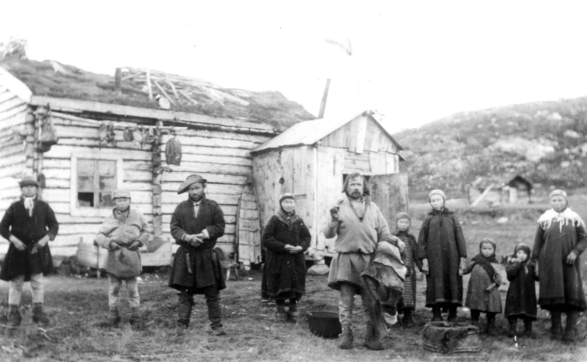 Familien Jon Andersen Must og Ole Persen Savio utenfor Musts hus, Sandnes, Sør-Varanger, før 1900.